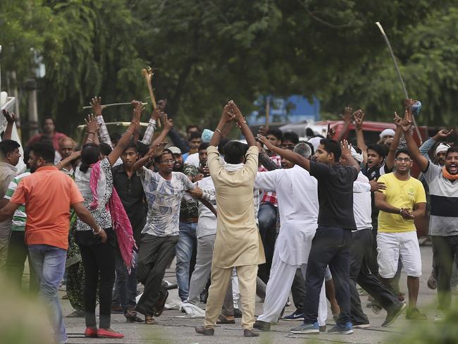 Supporters, back toward camera, try to calm other supporters of the Dera Sacha Sauda sect near an Indian court in Panchkula. Picture: AFP