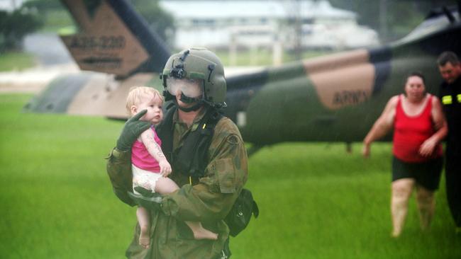 Warrant Officer Tony Young carries baby Montannah to drier land in Gatton in 2011. Picture: Jack Tran