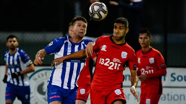 West Adelaide’s Tzoi Tsarkani in action against Adelaide United youth’s Jared Clark on Saturday. The young Reds won the clash 3-0. Picture: AAP/ Morgan Sette