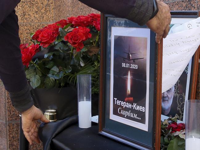 A man places a memorial poster showing a Ukrainian 737-800 plane that crashed on the outskirts of Tehran. Picture: AP