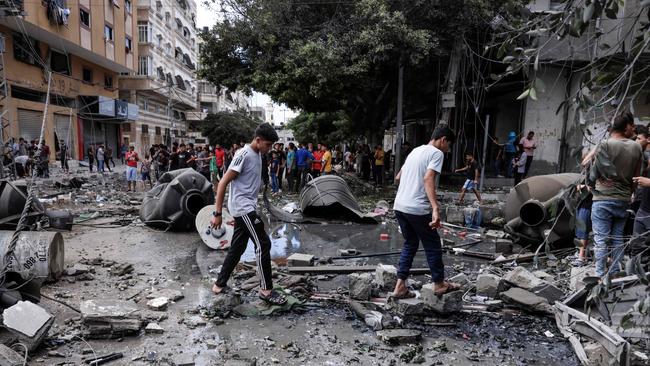 People assess the destruction cause by Israeli air strikes in Gaza City on October 7, 2023. Picture: Mohammed ABED / AFP