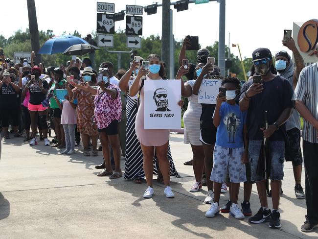 People lined the street to watch as a horse drawn hearse containing the remains of George Floyd drove past. Picture: AFP