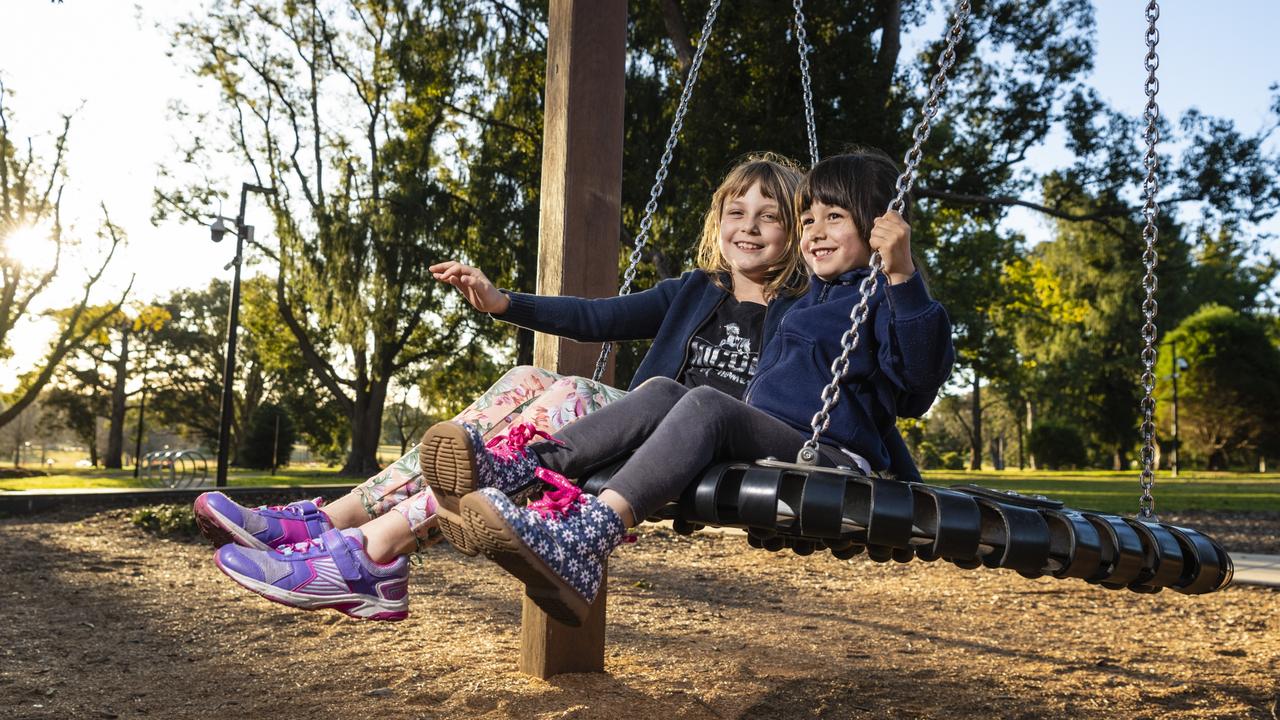 Annabelle Gwilliams (left) and her niece Brooklyn Gwilliams play on a swing in Queens Park, Saturday, July 30, 2022. Picture: Kevin Farmer