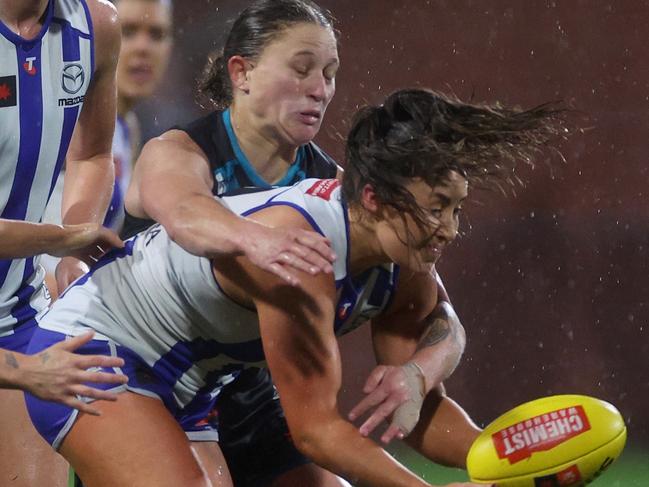 MELBOURNE, AUSTRALIA - SEPTEMBER 20: Nicole Bresnehan of the Kangaroos handballs whilst being tackled by Abbey Dowrick of the Power during the round four AFLW match between North Melbourne Kangaroos and Port Adelaide Power at Mission Whitten Oval, on September 20, 2024, in Melbourne, Australia. (Photo by Daniel Pockett/AFL Photos/via Getty Images)