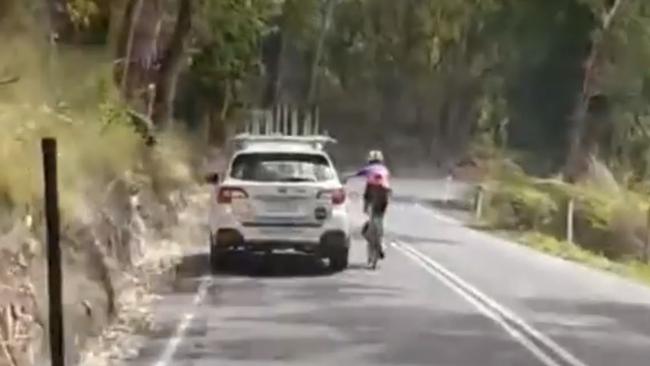 A pro cyclist holds on to a training car while traveling through the Adelaide Hills. Picture: 7 News