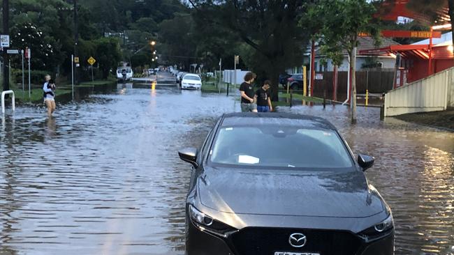 A car is stranded in floodwaters in Narrabeen. Picture: Jim O'Rourke