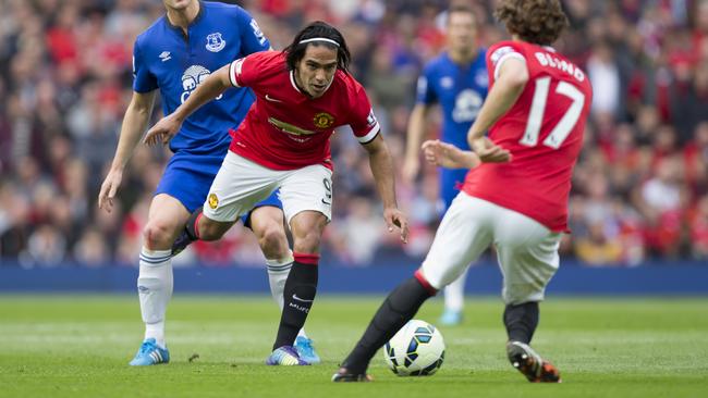 Manchester United's Radamel Falcao Garcia, center left, passes the ball to teammate Daley Blind as Everton's Gareth Barry, left, looks on during their English Premier League soccer match at Old Trafford Stadium, Manchester, England, Sunday Oct. 5, 2014. (AP Photo/Jon Super)