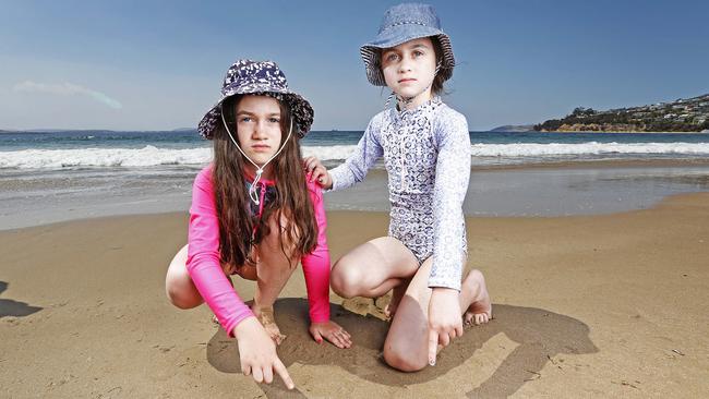 Sisters Eliza, 8 and Mathilda Brown, 9 of Blackmans Bay with jellyfish at Blackmans Bay Beach. Picture: ZAK SIMMONDS