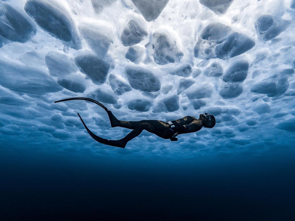 James Ferrara: A freediver gazes up at the ice patterns below the surface of a frozen lake. Canada
