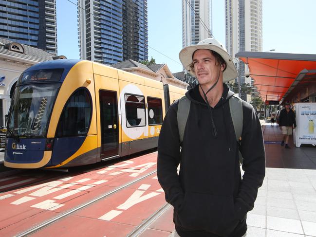 Josh Akehurst 27 from Broadbeach Waters gets off at the Light Rail station in Surfers Paradise.  Public transport usage has dropped 75 per cent with people fearing they can contract covid on the G. Picture Glenn Hampson