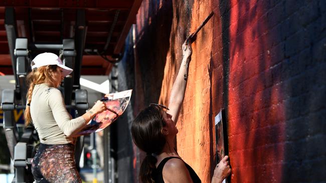 Artists paint a mural of Goodes in Surry Hills, Sydney. Picture: AAP