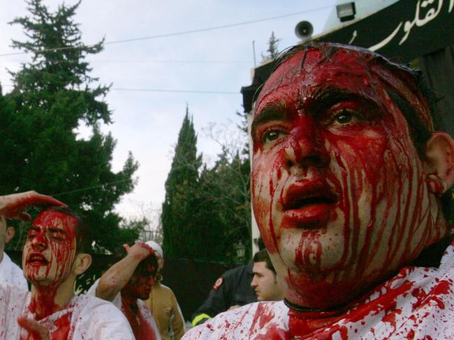 Lebanese Shiite Muslim men hit their heads as they mark the final day of Ashura in the southern Lebanese town of Nabatiyeh on December 27, 2009. Shiites in Iraq, Iran and Lebanon wrapped up the annual 10-day Ashura rituals which commemorate the killing of Imam Hussein, a grandson of the Prophet Mohammed, by armies of the Sunni caliph Yazid in 680. AFP PHOTO/MAHMOUD ZAYAT