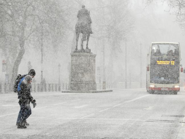 Pedestrians cross Whitehall as snow falls in London, Tuesday, Feb. 27, 2018. Heavy snow in parts of Britain is causing disruption to road, rail and air travel and has led to hundreds of schools being closed across the country. Picture: AP