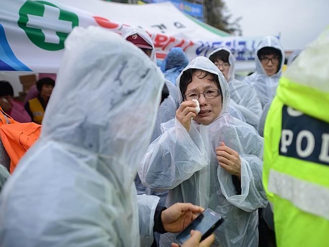 Hope fading ... a relative waits for news in a makeshift tent on the dock in Jindo, as coast guard officials admitted there was almost no chance of finding any of the missing hundreds alive. Picture: AFP