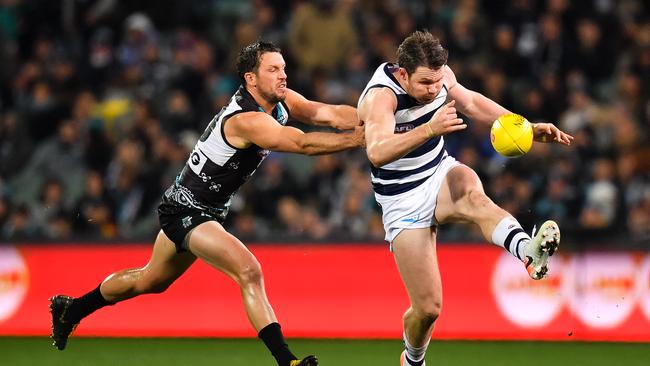 Geelong’s Patrick Dangerfield gets a kick away under pressure from Travis Boak in a Cats-Port clash last year. Picture: Daniel Kalisz/Getty Images