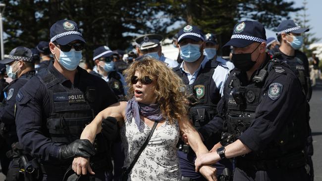 A protester is arrested near Main Beach, Byron Bay after a freedom protest moved from the courthouse to the beachfront on Saturday. Picture: Liana Boss