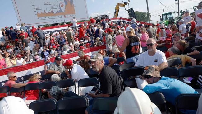 A stunned crowd evacuates the rally following the attempted assassination.