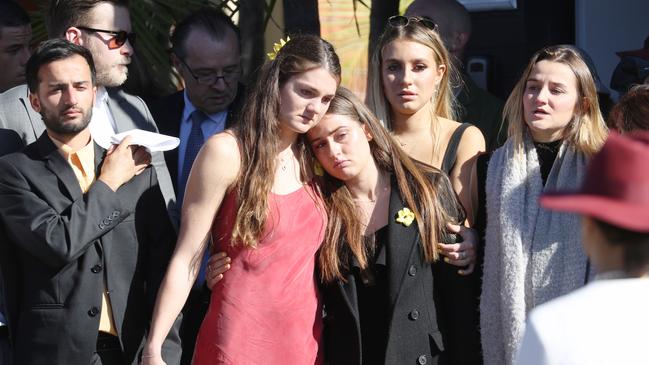 Friends of Annika Ferry Bec Bennett (in red dress) &amp; Eloise Lake (in Black) watch as the casket was moved into the car. Bec was with Annika when she died. picture John Grainger