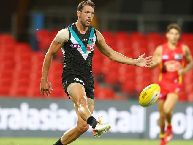 GOLD COAST, AUSTRALIA - MARCH 21: Trent McKenzie of the Power kicks during the round 1 AFL match between the Gold Coast Suns and the Port Adelaide Power at Metricon Stadium on March 21, 2020 in Gold Coast, Australia. (Photo by Chris Hyde/Getty Images)