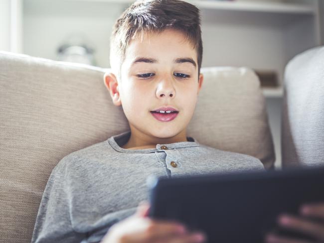 Boy using digital tablet in sofa at home