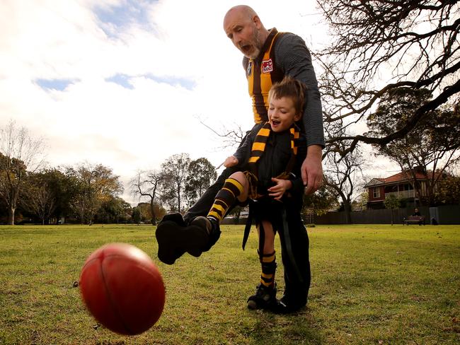 17/05/2018: Tony Wilson with his son Jack, 7. Jack has cerebral palsy but loves football so they started using an Upsee harness so he can play Auskick. Jack is harnessed to Tonyâ€™s legs so he can run and kick the ball. Stuart McEvoy for The Australian.