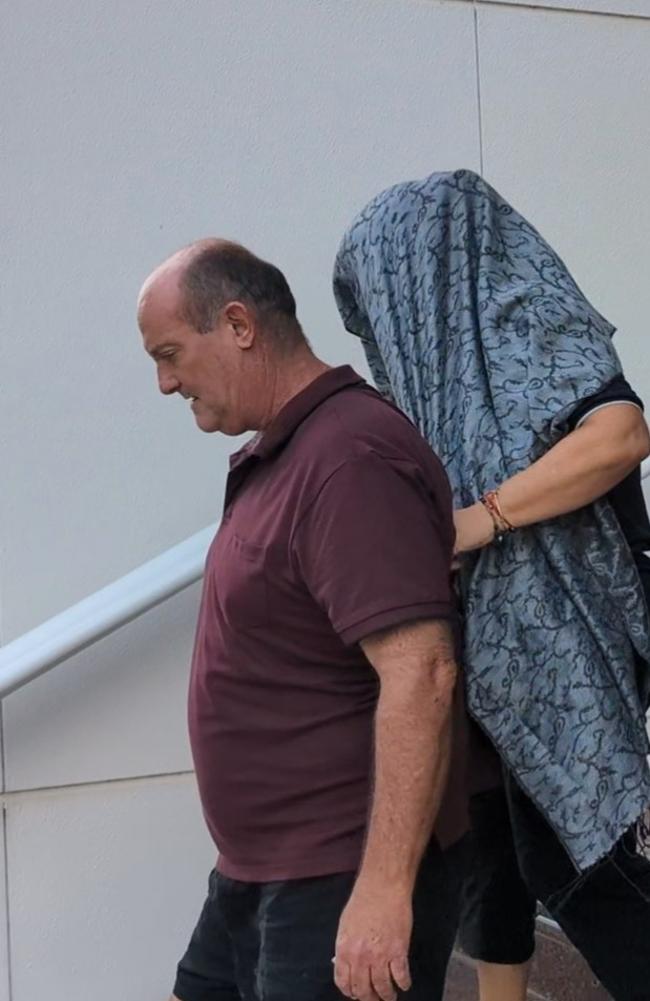 Angela Rita Marcus attempts to hide from a journalist outside of the Supreme Court in Darwin. Ms Marcus is charged with aiding another to commit an offence in relation to the alleged kidnapping of Grace Hughes. Picture: Zizi Averill