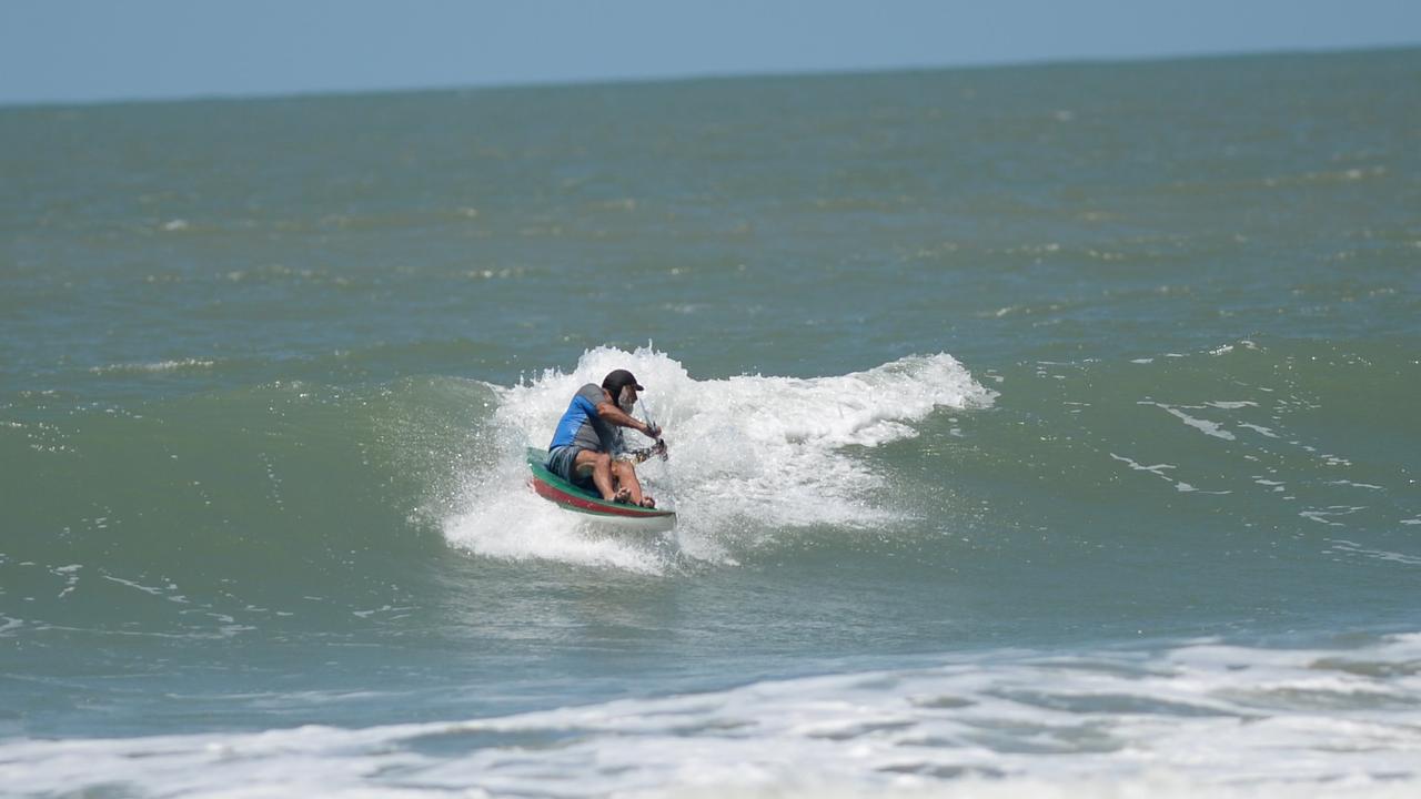 Surfers taking advantage of the swell at Mulambin Beach.