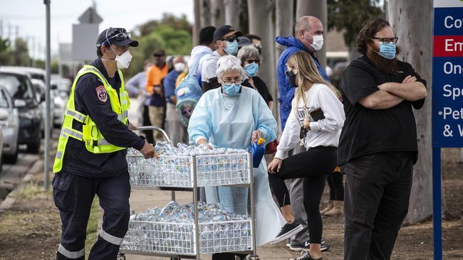 Health workers hand out water to the long queues of people at the Goulburn Valley Health Hospital. Picture: NCA NewsWire / Sarah Matray