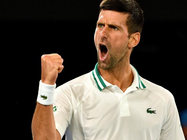 (FILES) This file photo taken on February 18, 2021 shows Serbia's Novak Djokovic reacting after a point against Russia's Aslan Karatsev during their men's singles semi-final match on day 11 of the Australian Open tennis tournament in Melbourne. - World number one Novak Djokovic won a stunning victory on January 10, 2022 over the Australian government, overturning the cancellation of his visa on Covid-19 health grounds, and ending his detention. (Photo by Paul CROCK / AFP) / -- IMAGE RESTRICTED TO EDITORIAL USE - STRICTLY NO COMMERCIAL USE --