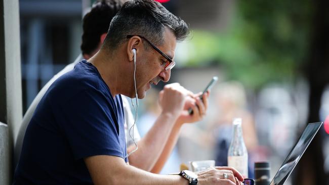 SYDNEY, AUSTRALIA - NewsWire Photos MARCH 29, 2021:  A man is seen working on his laptop at a cafe in the CBD as the federal subsidy scheme Job Keeper comes to an end in Sydney Australia. Picture: NCA NewsWire / Gaye Gerard