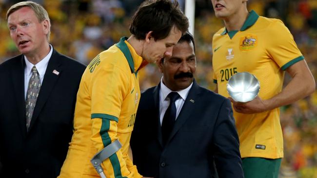 Robbie Kruse collects his trophy on crutches.