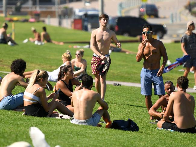 Bondi Beach is closed, but tourists continued to gather on the grass nearby on Tuesday. Picture: AAP