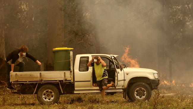 Jamie Fato prepares to stop an out of control fire entering Owen Whalan's property at Koorainghat, near Taree in the Mid North Coast region of NSW. Picture: AAP