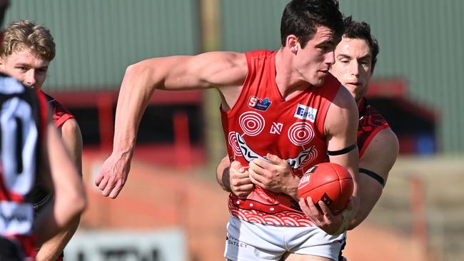 North Adelaide’s Dyson Hilder dishes out a handball under pressure against West Adelaide at Richmond Oval. Picture: Keryn Stevens