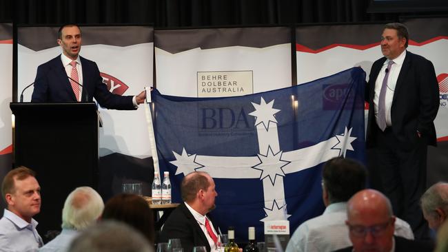 Stephen Galilee, left, presents Lucas Dow with a Eureka flag in Sydney yesterday. Gladly thy Southern Cross I bear. Picture: Hollie Adams