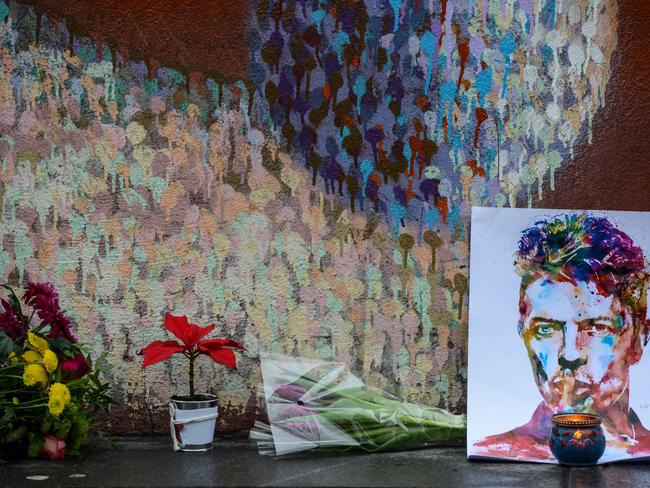 Floral tributes ... left beneath a mural of British singer David Bowie, following the announcement of Bowie's death, in Brixton, south London. Picture: AFP