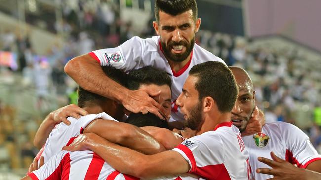 Jordan's players celebrate their opening goal during the 2019 AFC Asian Cup group B football match between Jordan and Syria at the Khalifa bin Zayed stadium in al-Ain on January 10, 2019. (Photo by Giuseppe CACACE / AFP)