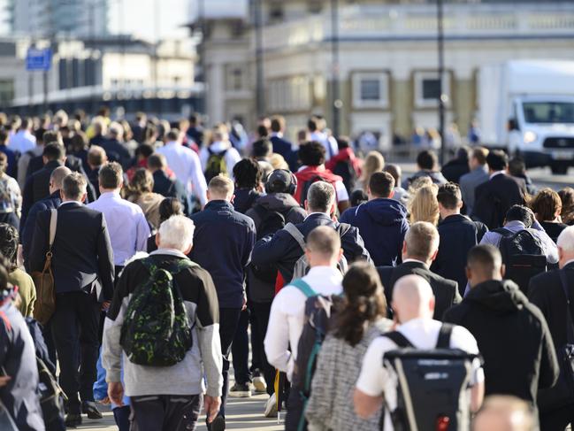 Large crowd of people commuting to work in London, England