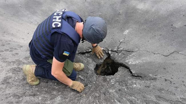 A rescuer examines a crater after a Russian shelling in Kharkiv. Picture: AFP