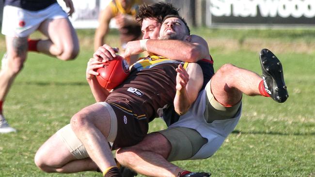 Thomastown Anthony Capeci cops a coat hanger from a Diamond Creek opponent during their Northern Football League match. Picture: Aaron Cook.