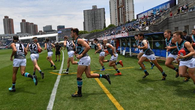 Power players run onto Jiangwan Stadium for the clash against St Kilda in Shanghai. Picture: AAP Image/David Mariuz