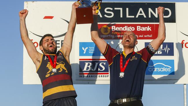 Two more years: triple premiership coach Steve Buckle (right) lifts the 2019 Division 1 cup. Picture: Valeriu Campan