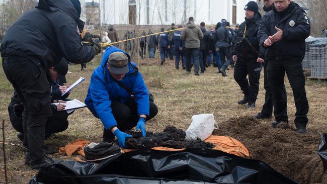 A forensic team remove the bodies of a mother and two children on April 12, 2022 in Bucha, Ukraine. The Russian retreat from towns near Kyiv has revealed scores of civilian deaths and the full extent of devastation from Russia's attempt to seize the Ukrainian capital.