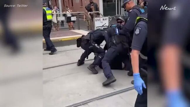 Police arrest protesters outside Parliament House on Spring St on Saturday