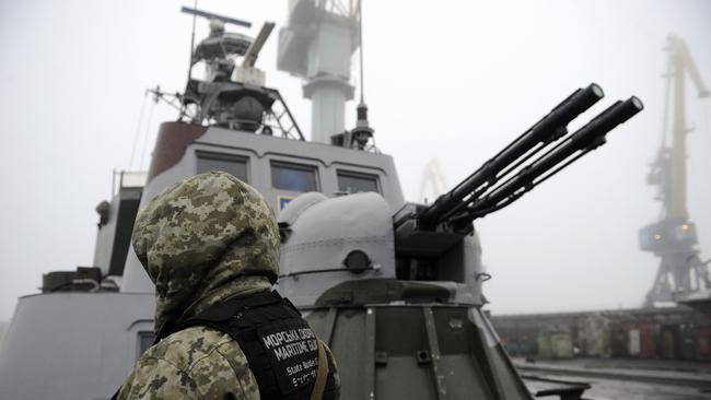 A Ukrainian soldier patrols aboard a military boat moored in the Sea of Azov. Picture: AFP