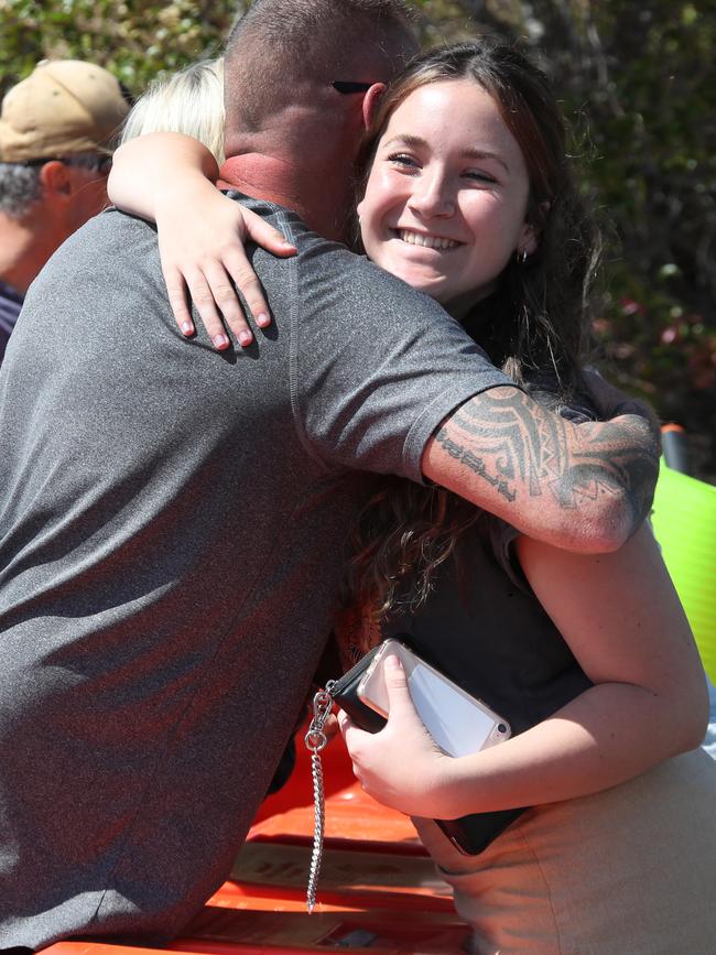 Family members hug and at the NSW-Queensland border.