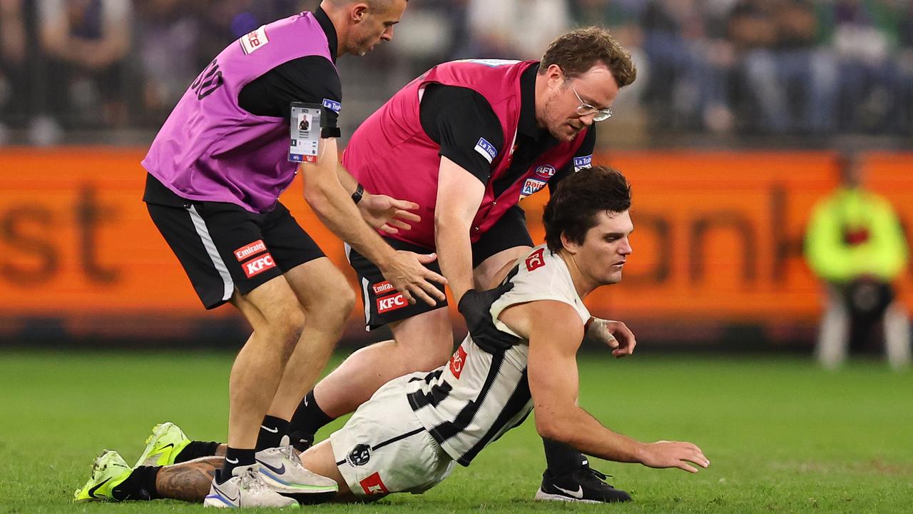 Lachie Schultz of the Magpies collapses in the hands of medical staff. Photo by Paul Kane/Getty Images.