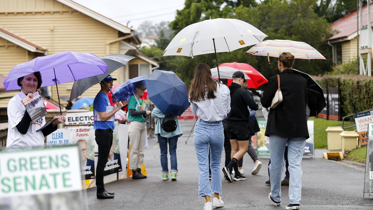 Voters bracing the wet weather at Wilston State School in Brisbane on their way to the polling booth. Picture: Josh Woning