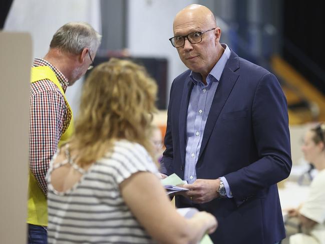 Australian Liberal Party leader Peter Dutton talks with an election official as he prepares to vote in his electorate in Brisbane, Australia, Saturday, May 3, 2025. (AP Photo/Pat Hoelscher)