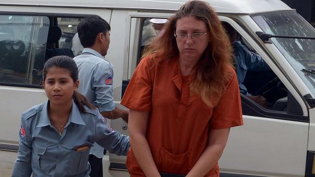 French woman Charlene Savarino (C) and Australian woman Yoshe Ann Taylor (R) are escorted by Cambodian prison guards at the Phnom Penh municipal court on May 28, 2014. A Cambodian court sentenced three foreign nationals to prison between 23 and 27 years on May 28 for trying to smuggle 2.2 kilograms of heroin to Australia. AFP PHOTO/TANG CHHIN SOTHY